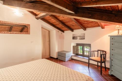 a bedroom with a bed and a chair in a room at Casale di Polly in Garfagnana in Minucciano