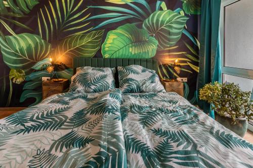 a bedroom with a bed with a mural of plants at Hotz in Radolfzell am Bodensee