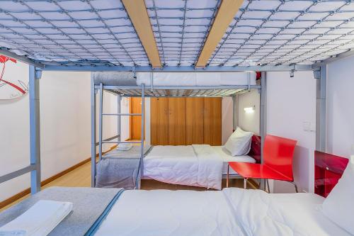 a room with a bed and a bed and a chair at HI Vila Nova de Cerveira - Pousada de Juventude in Vila Nova de Cerveira
