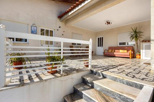 a porch of a house with a white fence at Villa da Floresta in Arcos