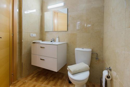 a bathroom with a toilet and a sink and a mirror at Apartamento Ye in Haría
