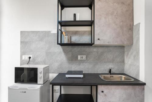 a kitchen with a sink and a microwave at Casa Vacanze Sa Domixedda in Guspini