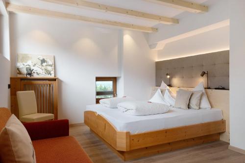 a bedroom with a large white bed with white pillows at Kristiania Apartement Typ B in Siusi