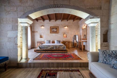 a bedroom with a king sized bed in a stone wall at Divan Cave House in Göreme