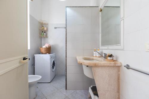a bathroom with a sink and a toilet and a mirror at Casa Loretta 3 in Valledoria