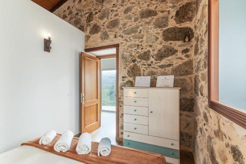 a room with a bedroom with a stone wall at Casa Eloisa in Teror