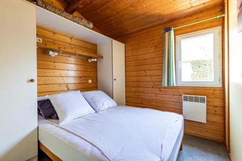 a bedroom with a bed in a wooden cabin at Chalet Yoya in Lanton