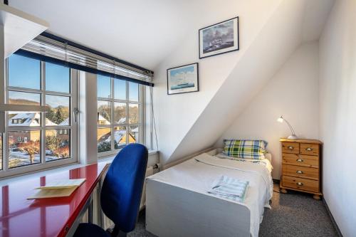 a bedroom with a bed and a desk and a window at Haus Übersee Wohnung Sansibar in Travemünde