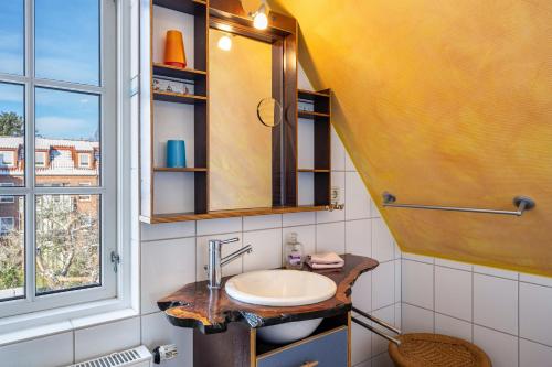 a bathroom with a sink and a window at Haus Übersee Wohnung Sansibar in Travemünde