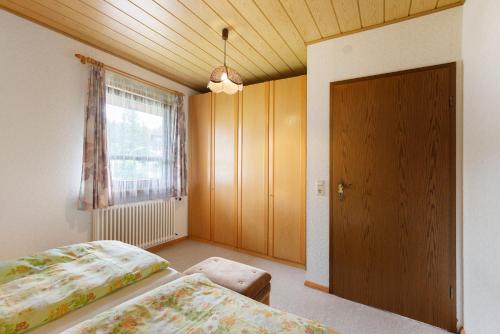 a bedroom with a bed and a window and a door at Ferienwohnung Haus Barbara in Bräunlingen