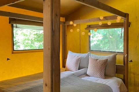 a bedroom with a bunk bed and a bed with pillows at Camping 7Huizen aan Zee in Scharendijke