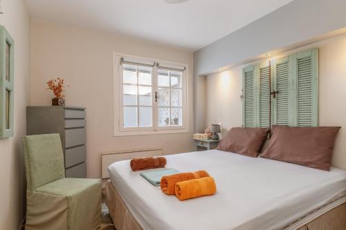 a bedroom with a bed and a chair and windows at Waterfront Masterpiece in Tinos