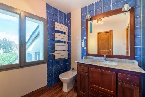 a bathroom with a sink and a toilet and a mirror at Maison avec piscine in Marciac