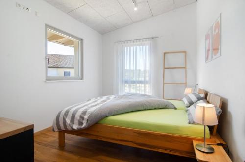 a bedroom with a bed and a window at Ferienwohnungen Walz in Pfullendorf