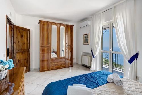 a bedroom with a blue bed and a balcony at Villa Azzurra in Massa Lubrense