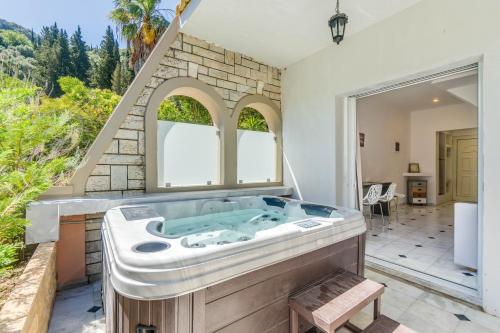 a jacuzzi tub in a room with a window at Doliva Studio John private jacuzzi in Agios Gordios