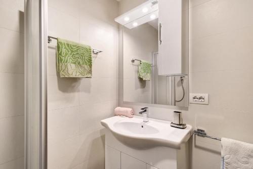 a white bathroom with a sink and a mirror at Pension Waldheim Apartments in San Giacomo
