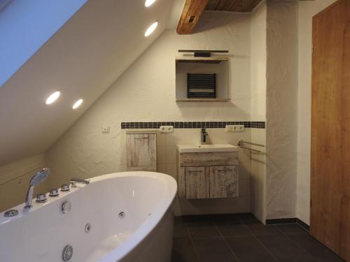 a bathroom with a bath tub and a sink at Rosenzauber-Seeromantik in Weißenstadt
