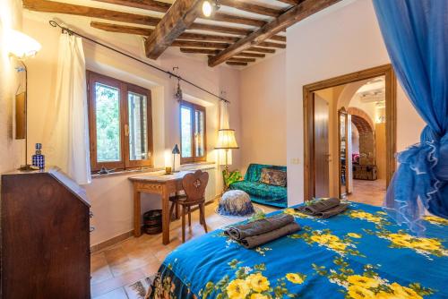 a bedroom with a blue bed and a mirror at Paradis Oasis Santa Maria in Chiusdino