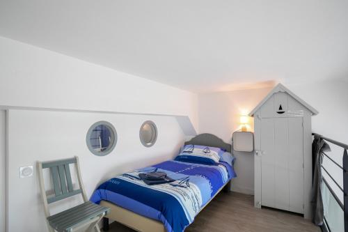 a small bedroom with a bed and a chair at Ti Roz - Vue mer in Perros-Guirec