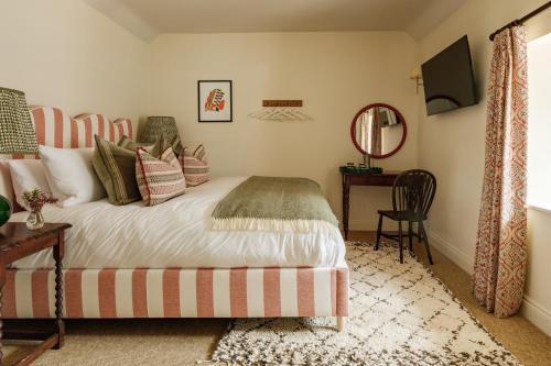 a bedroom with a bed and a table and a mirror at The Queen's Head in Broad Chalke