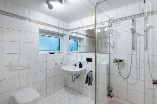 a white bathroom with a shower and a sink at Naturoase Fichtelberg in Fichtelberg