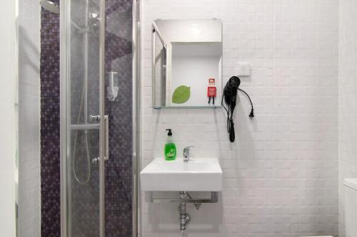 a bathroom with a sink and a shower with a mirror at Apartamento nº3 - Familiar in Moncarapacho