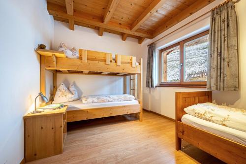 a bedroom with two bunk beds and a window at Raffreiderhof Apt Fichte in Luson