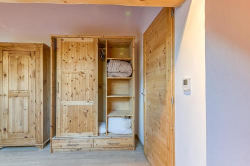 a closet with wooden doors and shelves in a room at Chalet Arvina in Saint-Jean-dʼArves