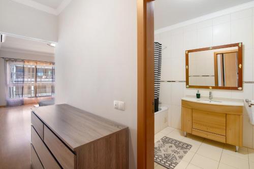 a bathroom with a sink and a mirror at Apartamento Armação de Pêra in Armação de Pêra