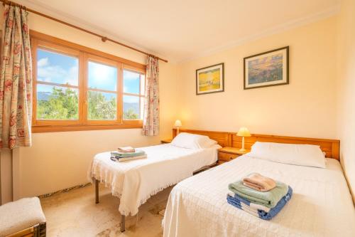 two beds in a room with a window at Montemar 34 in Port de Soller