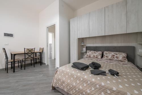 a bedroom with a bed with two black towels on it at Casa Andrea in Assemini
