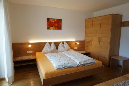 a bedroom with a bed and a cabinet at Waalhof Ferienwohnung Mohnblume in Silandro
