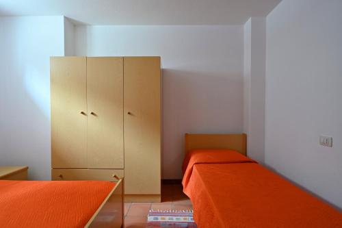 a small bedroom with two beds and a cabinet at Casa Spaziosa in Bari Sardo