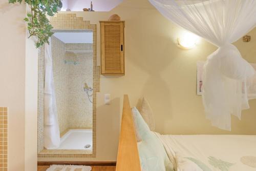 a bedroom with a bed and a mirror and a window at Casa Lago - Selão da Eira in São Teotónio