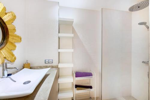 a white bathroom with a sink and a mirror at Casa Rewa in Port d'Alcudia