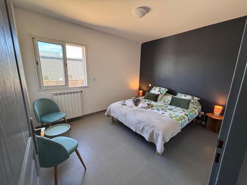 a bedroom with a bed and two chairs in it at Villa Lucia in Narbonne