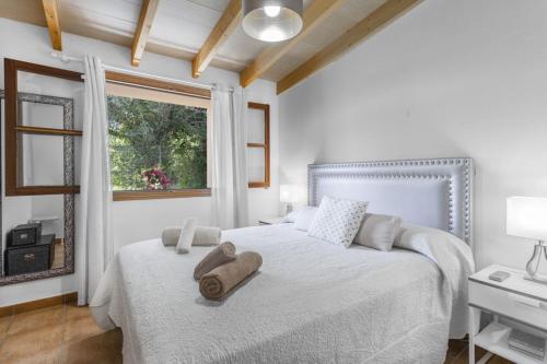 a white bedroom with a large bed with a window at Sa Vinya de Son Bou in Sóller