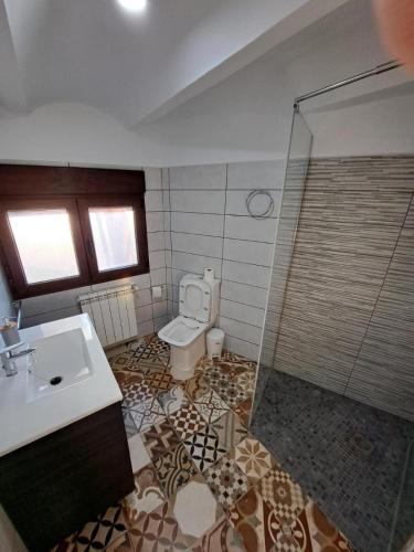 a bathroom with a toilet and a sink and a shower at Casa Pedro in Vélez-Rubio