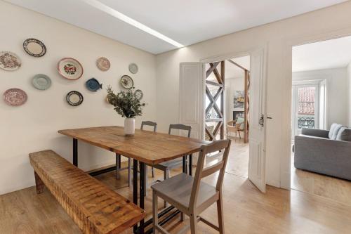a dining room with a wooden table and a bench at Apartamento central com vista rio in Lisbon