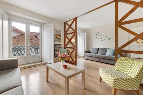 a living room with a couch and a table at Apartamento central com vista rio in Lisbon
