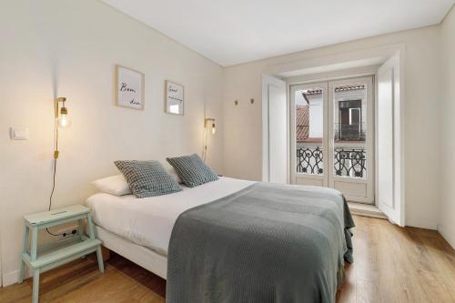 a bedroom with a bed and a window at Apartamento central com vista rio in Lisbon