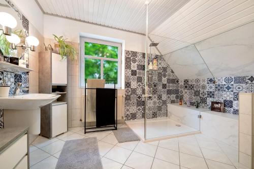 a bathroom with a shower and a tub and a sink at Inge Huus in Hude