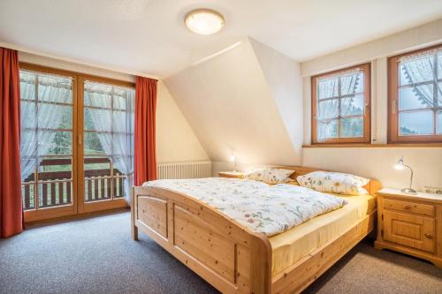 a bedroom with a wooden bed and windows at Vogtshof in Bad Rippoldsau-Schapbach