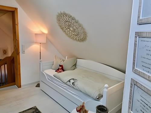 a white bed in a room with a lamp at Quartier Sängerstadt in Finsterwalde