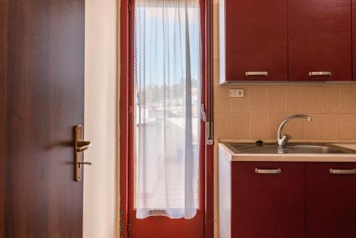 a kitchen with a sink and a door with a window at Appartamento C - Le Terrazze in Ribera