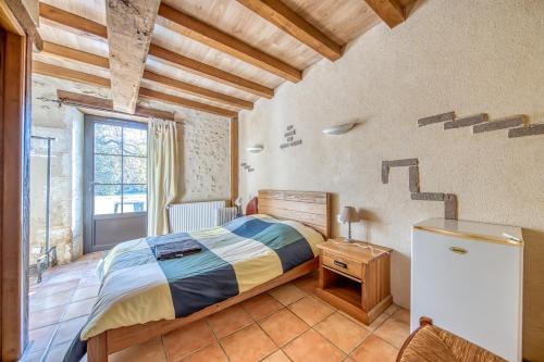 a bedroom with a bed in a room with wooden ceilings at Le Moulin in Guizengeard