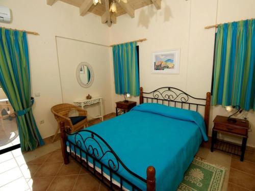 a bedroom with a blue bed and blue curtains at Sami Beach Villas Dafni in Sami