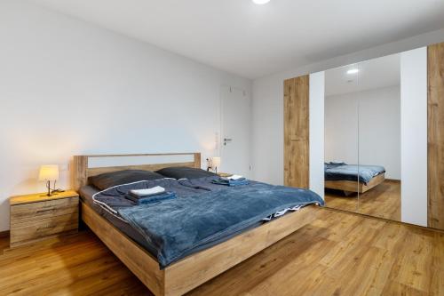 a bedroom with a large bed and a mirror at Fewo im Eichengrund in Rheinhausen