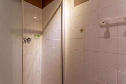 a bathroom with a shower with white tiles at Maison de vacances Camille in Artigues